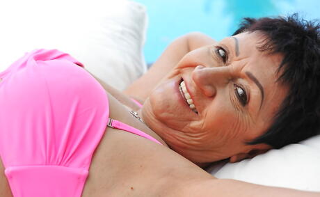 Delightful grannie Anastasia in hot lingerie reveals big tits and shaved pussy at pool